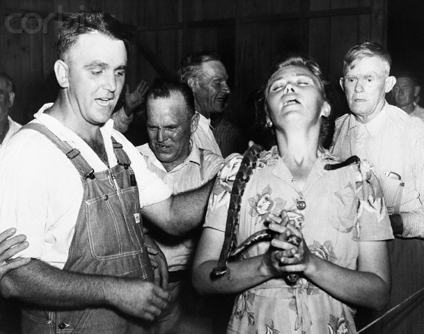 1945 --- 1945- Lewis Ford is shown as he draped a rattlesnake about he neck of a member of his congregation. --- Image by © Bettmann/CORBIS