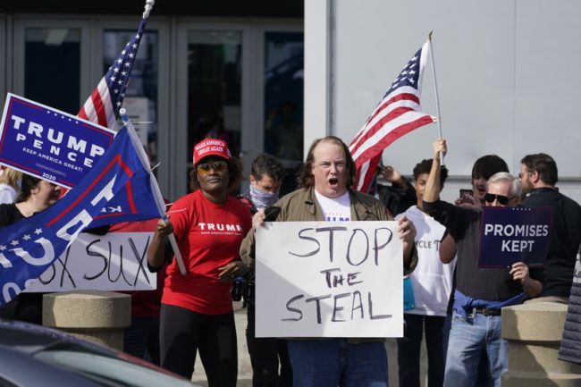 Supports of President Donald Trump holds signs during a demonstration outside the State Farm Arena where Fulton County has a voting counting operation, Thursday, Nov. 5, 2020, in Atlanta. (AP Photo/John Bazemore)